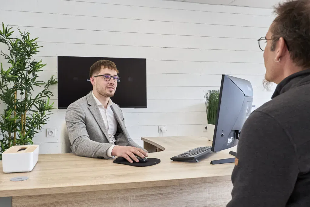 Conseiller funéraire à son bureau à l'écoute d'un client lors d'un entretien d'accompagnement.